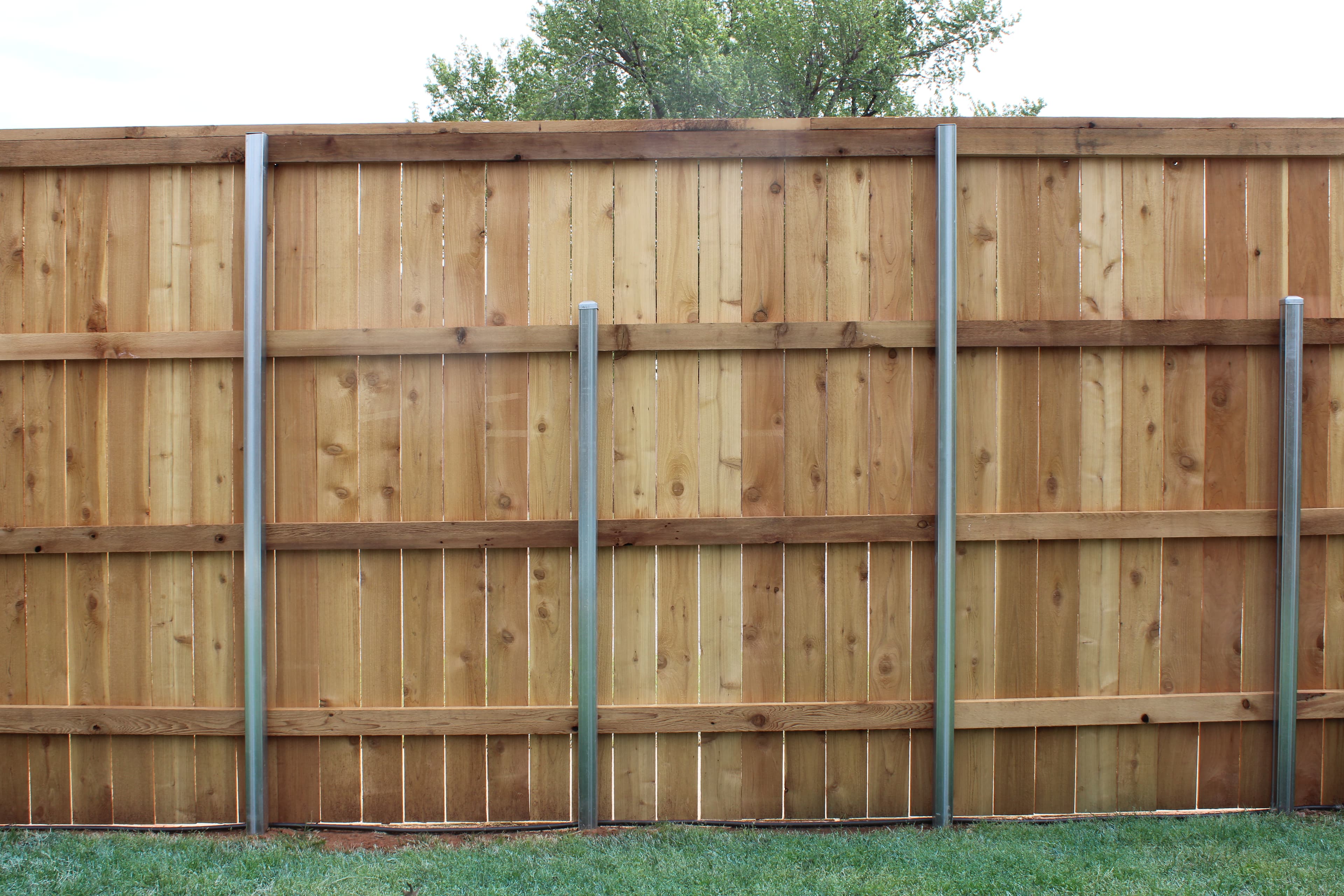A new cedar privacy fence going up on galvanized metal posts in Oklahoma City